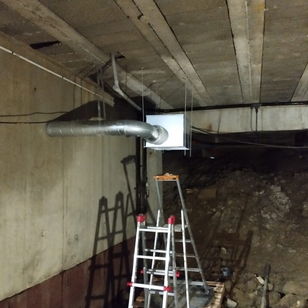 Travaux de ventilation en sous-sol avec conduit métallique et escabeau par atelec à bordeaux