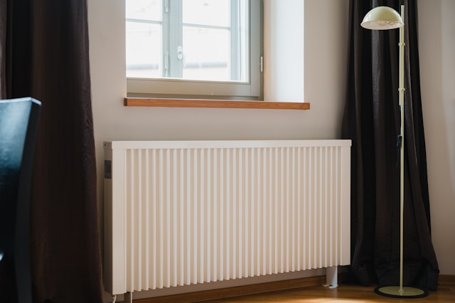 Radiateur moderne vertical installé par atelec dans un salon lumineux à Bordeaux