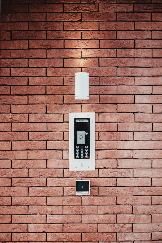 applique et interphone modernes sur mur de briques rouges installés par atelec à bordeaux